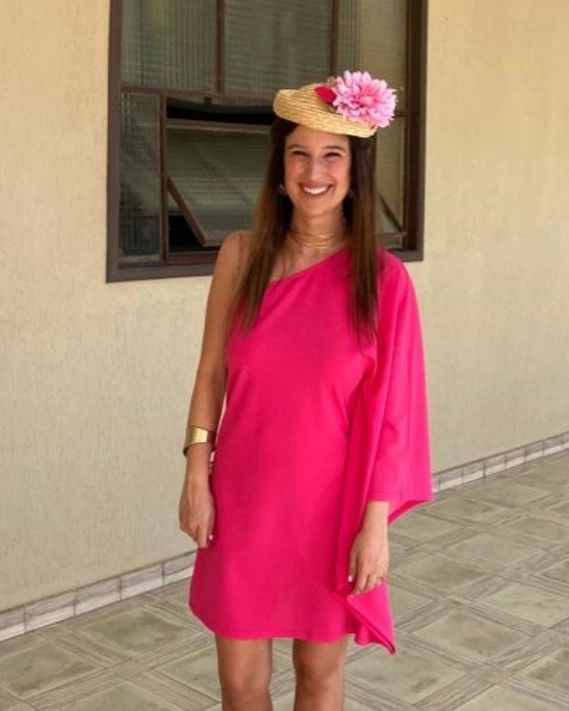 chica con vestido fucsia y sombrero con flores rosas